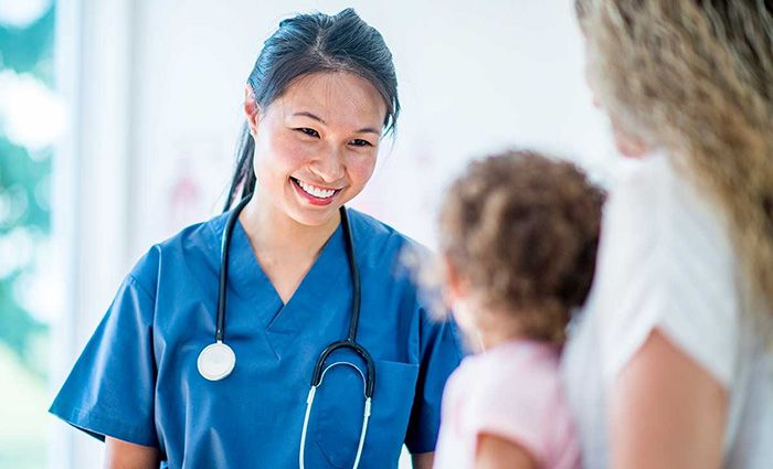 physician speaking with woman and her young daughter